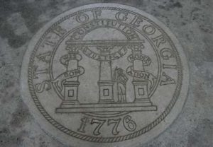 Figure 1. A picture of the Seal of the state of Georgia (dated 1776), engraved intostone. The description on the seal has three columns labeled “wisdom,” “justice,” and “moderation,” with a semi-circle labeled “constitution connecting the three. Photo by Gary Lee Todd under CC0 1.0 public domain license.
