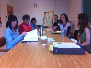 Six adults sitting at a table to discuss the health care needs of a child with special needs